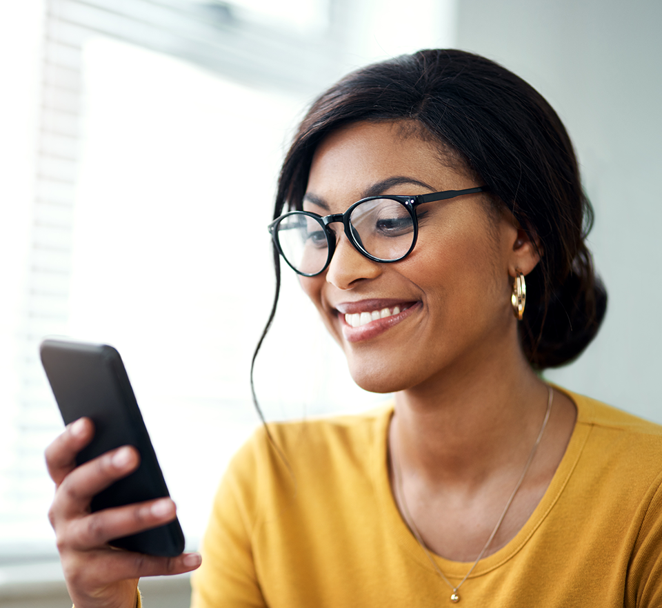 Photo of smiling woman reading smartphone